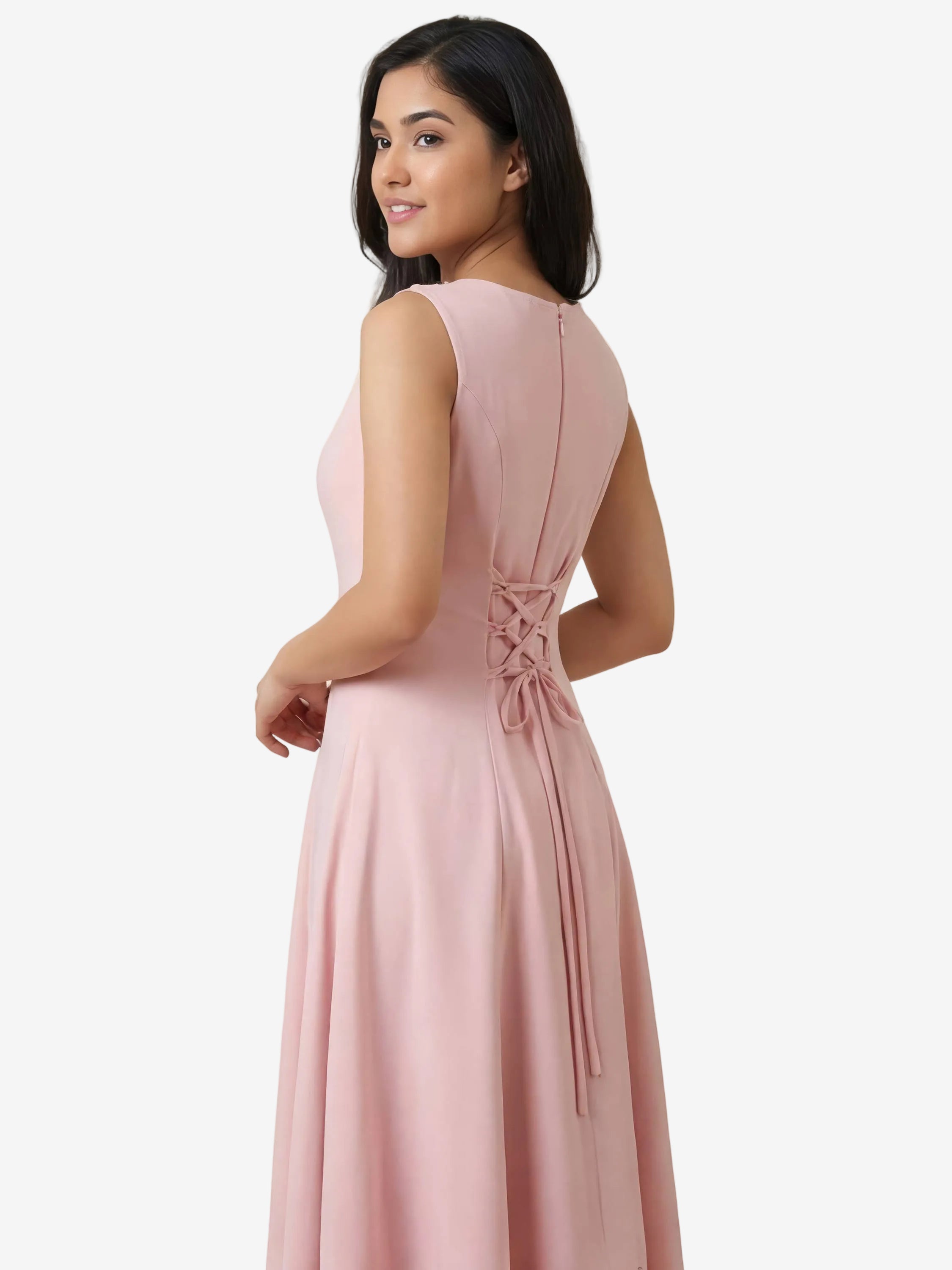 Woman wearing a pink dress with a bow detail on a beige background
