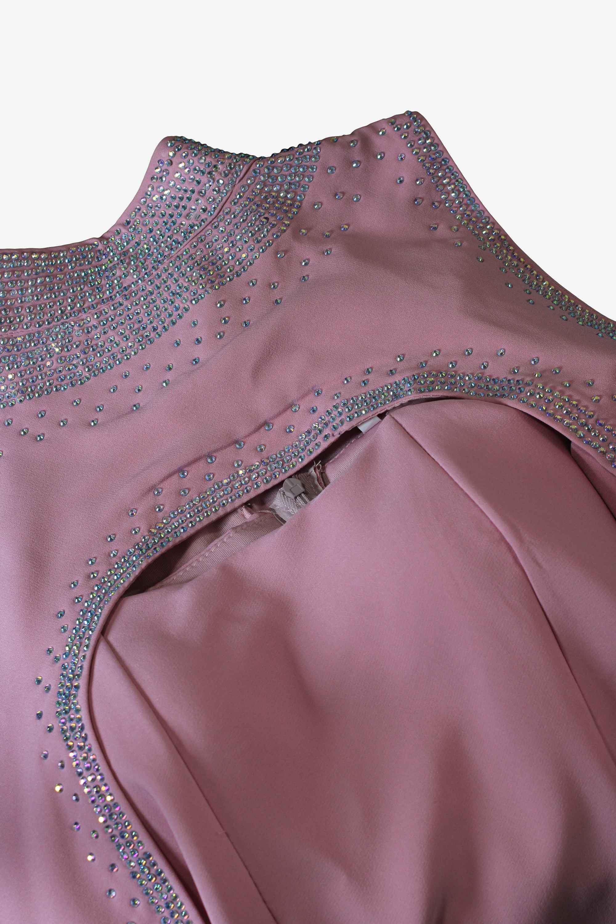 Close-up of a pink dress with sparkling embellishments on a white background