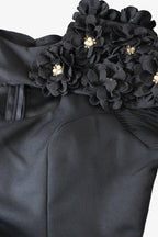 Black floral shoulder detail on a garment with gold accents.