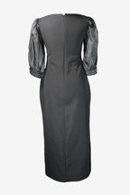 Black dress with embellished sleeves on a white background