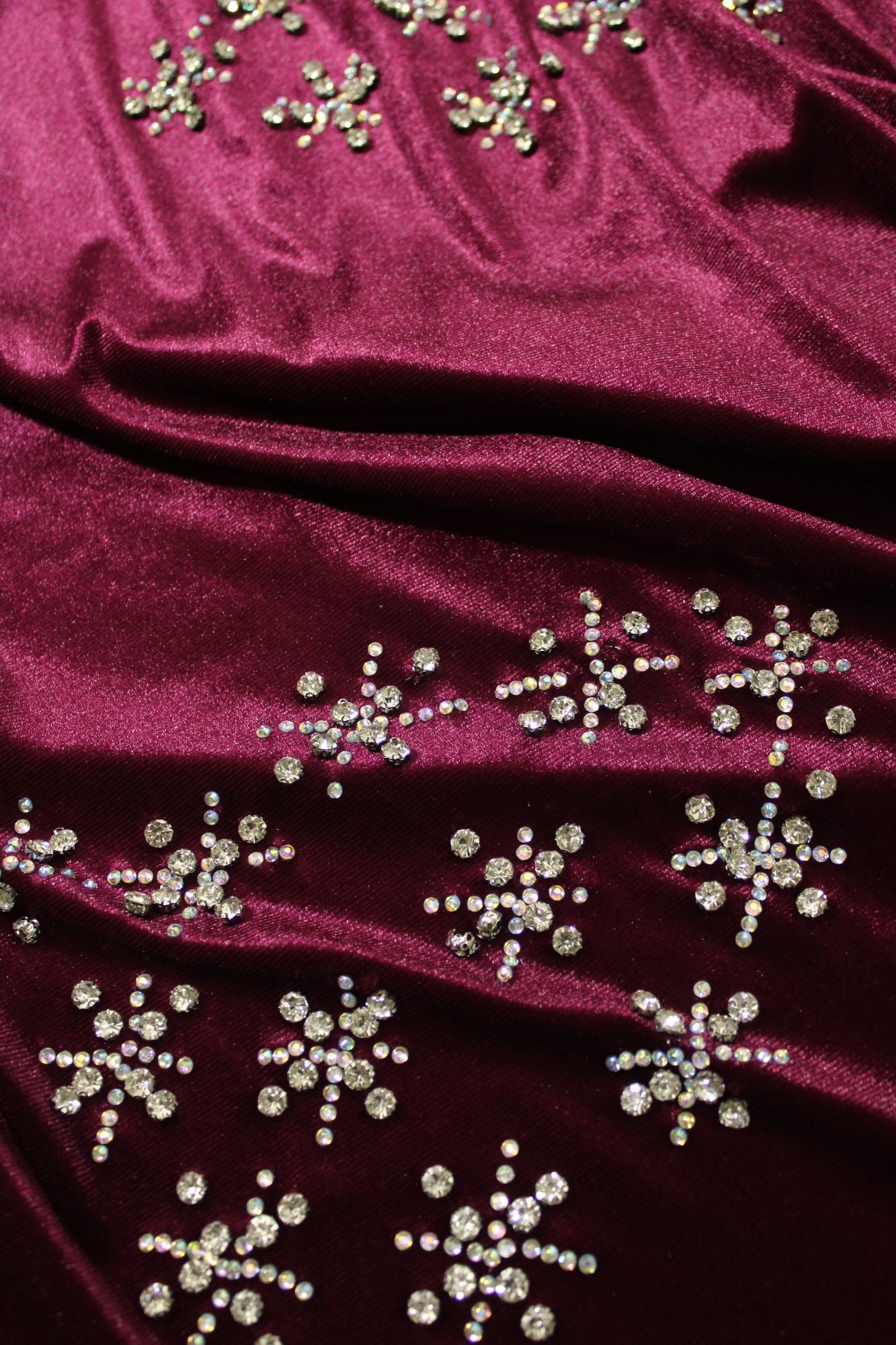 Close-up of burgundy fabric with gold bead embellishments