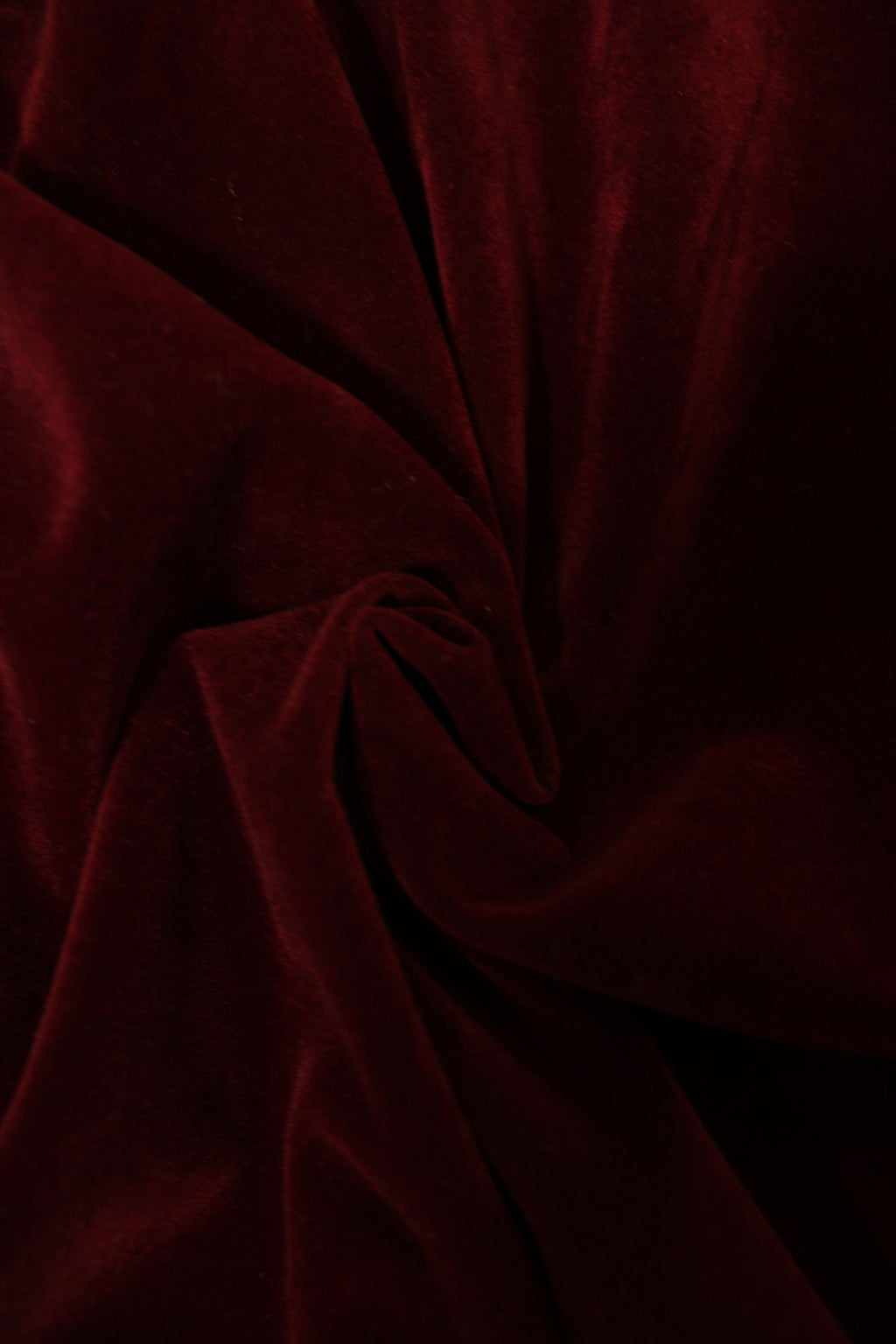 Close-up of dark red velvet fabric with folds