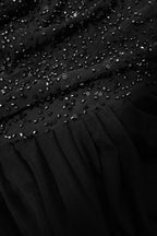 Close-up of a black dress with sequin detailing
