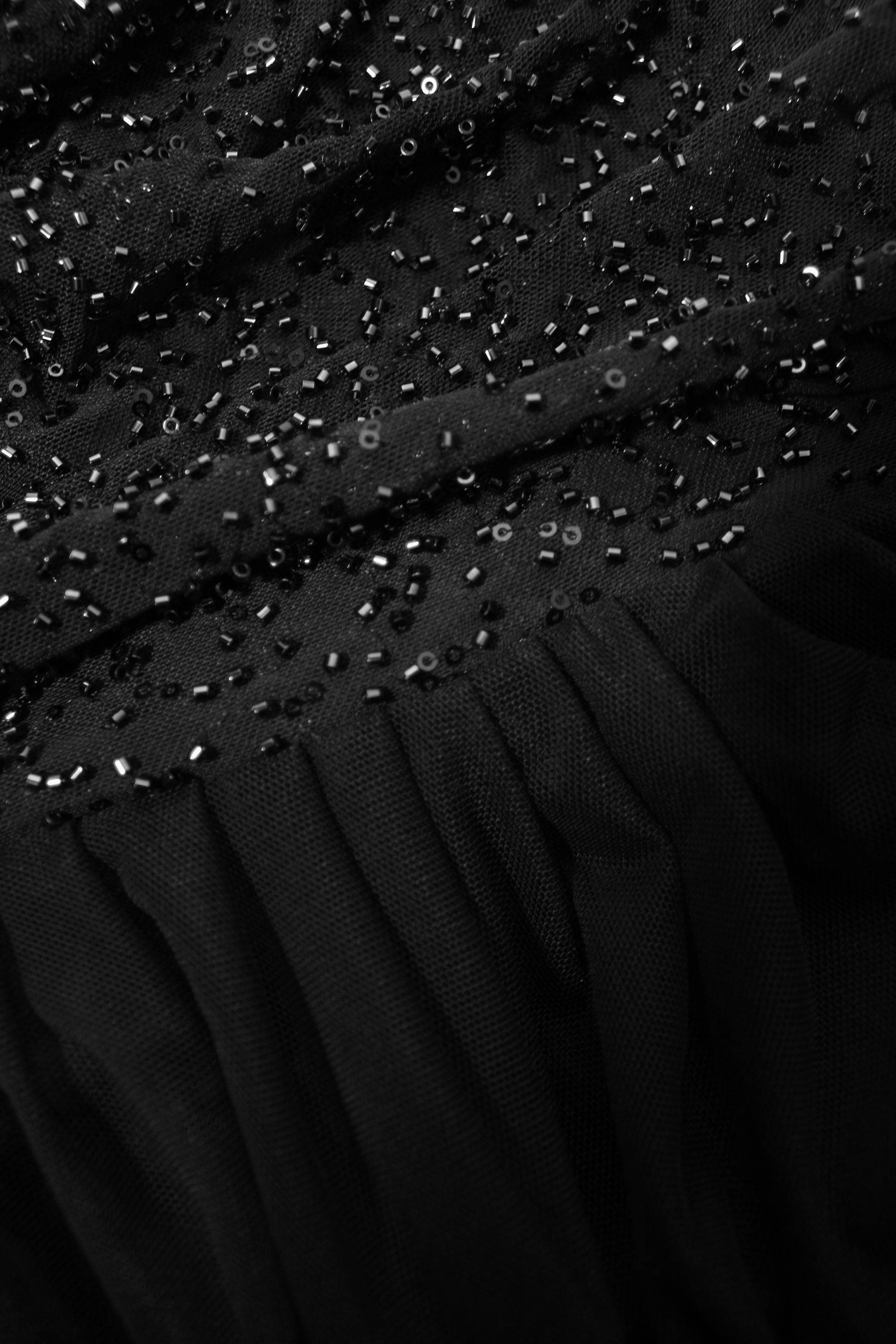 Close-up of a black dress with sequin detailing
