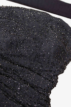 Close-up of black sequined fabric with a white background