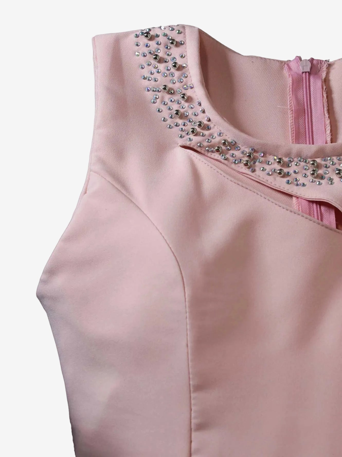 Pink top with embellished neckline on a light pink background