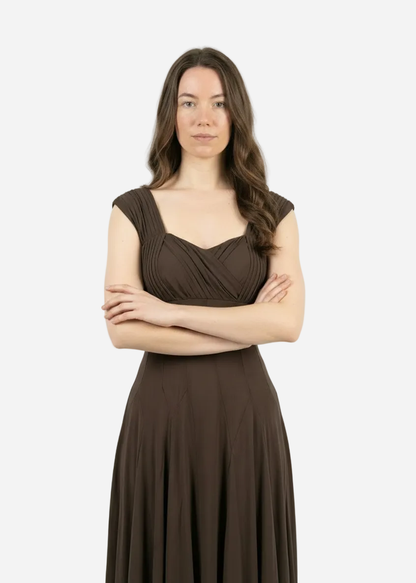 Woman wearing a brown dress with her arms crossed on a white background
