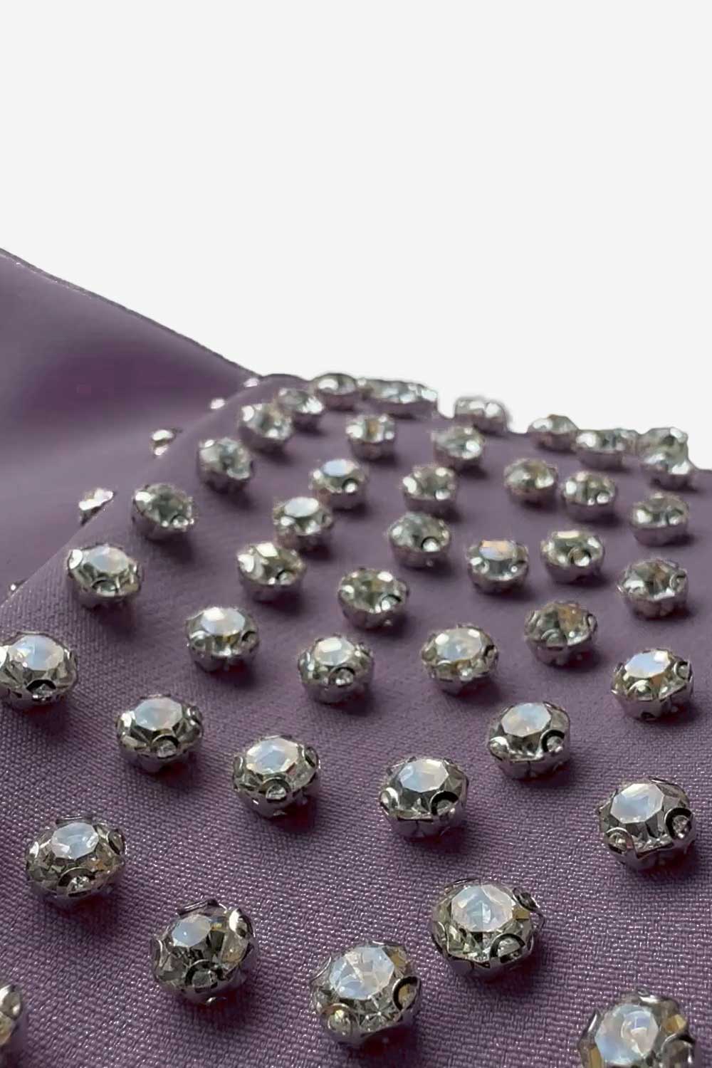 Silver rhinestones on a purple fabric background