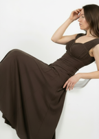 Woman wearing a brown dress against a white background